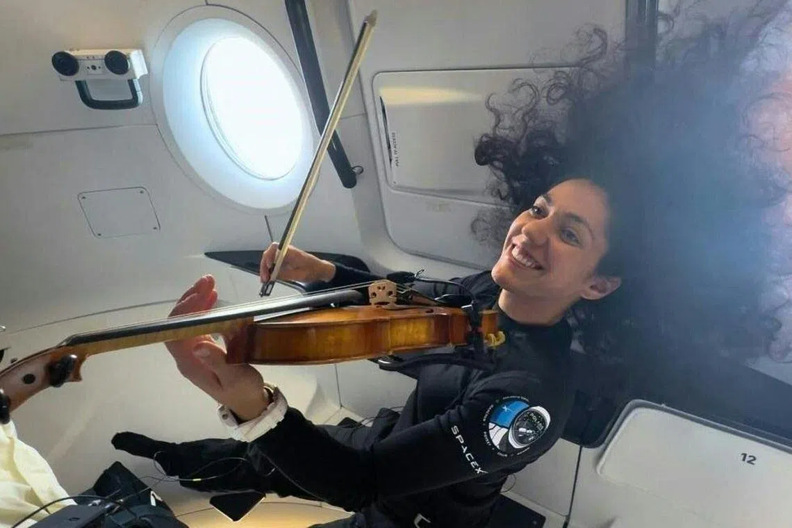 This still image taken from Polaris Dawn crew obtained on September 14, 2024, shows Mission Specialist Sarah Gillis playing “Rey’s Theme” by John Williams on the violin during the SpaceX Polaris Dawn mission. The SpaceX Polaris Dawn mission, which made history when its crew conducted the first ever spacewalk by non-government astronauts, is preparing for splashdown off the coast of Florida on September 15, 2024. (Photo by Handout / Polaris Program / AFP) / RESTRICTED TO EDITORIAL USE - MANDATORY CREDIT "AFP PHOTO / SpaceX / Polaris" - NO MARKETING NO ADVERTISING CAMPAIGNS - DISTRIBUTED AS A SERVICE TO CLIENTS