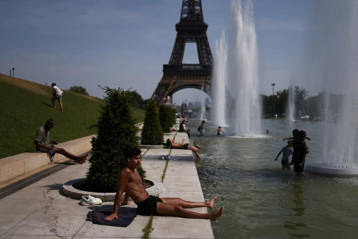 A person sunbathes next to the Trocadero Fountains by the Eiffel Tower during high temperatures amid a heatwave in Paris, France, June 27, 2026. REUTERS/Tom Nicholson