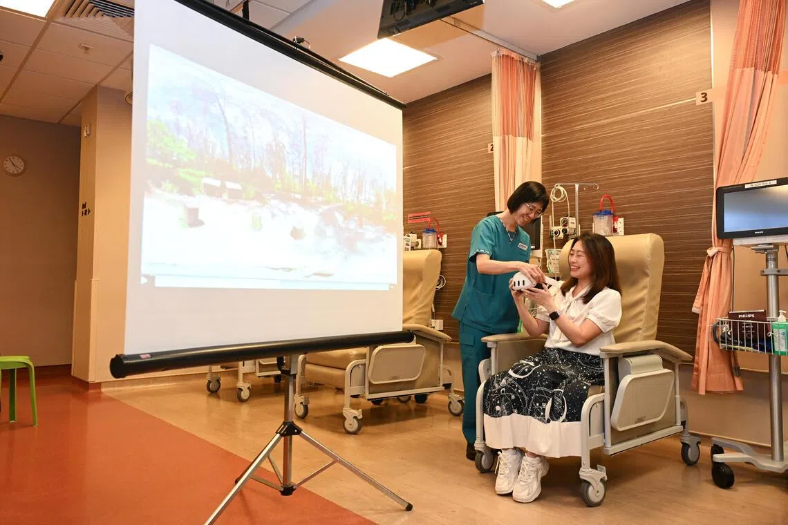 Eileen Tan (right) used the virtual reality headset to calm her nerves before her fibroid removal surgery in May. Assisting her is Ong Siok Hoon, nurse clinician at KK Women’s and Children’s Hospital’s day surgery department.