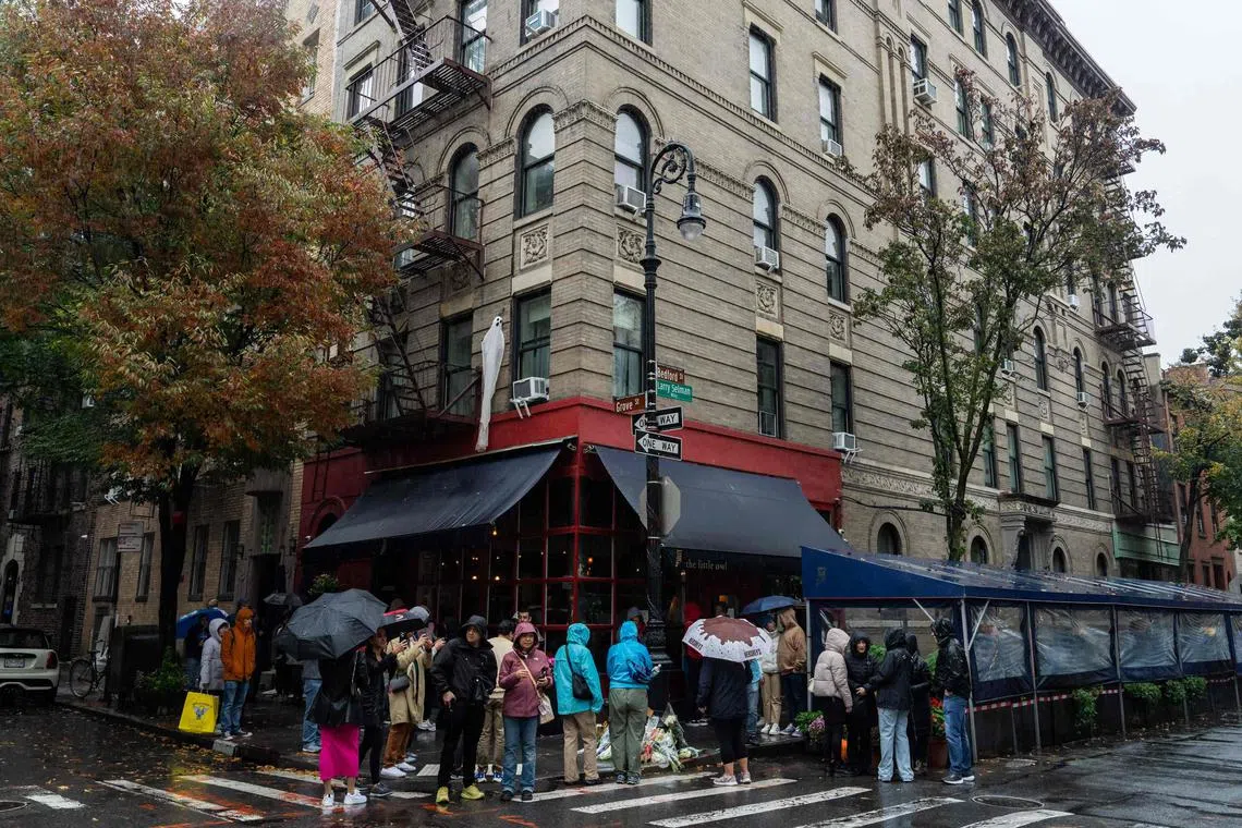 TOPSHOT - People stand in line to pay tribute to actor Matthew Perry outside the apartment building which was used as the exterior shot in the TV show "Friends" in New York on October 29, 2023. Perry, 54, was known globally for his portrayal of wise-cracking character Chandler Bing on the wildly popular "Friends," which ran for 10 seasons from 1994 to 2004. First responders found Perry unconscious in a hot tub at his house on October 28 and were unable to revive him, law enforcement sources told the Los Angeles Times. Police confirmed they'd mounted a "death investigation for a male in his 50s." (Photo by Adam GRAY / AFP)