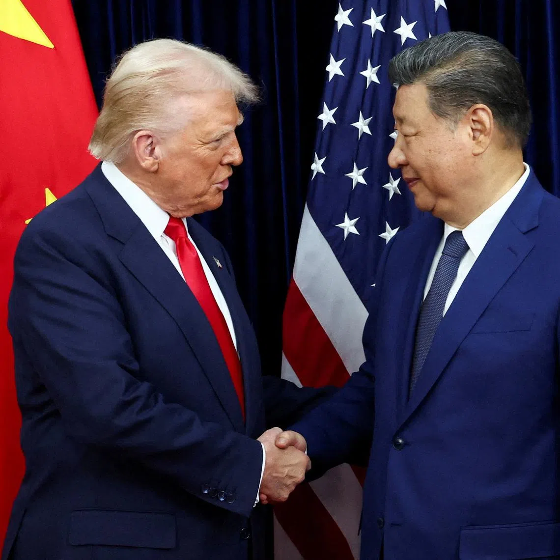 FILE PHOTO: U.S. President Donald Trump shakes hands with Chinese President Xi Jinping as they hold a bilateral meeting at Gimhae International Airport, on the sidelines of the Asia-Pacific Economic Cooperation (APEC) summit, in Busan, South Korea, October 30, 2025. REUTERS/Evelyn Hockstein/File Photo