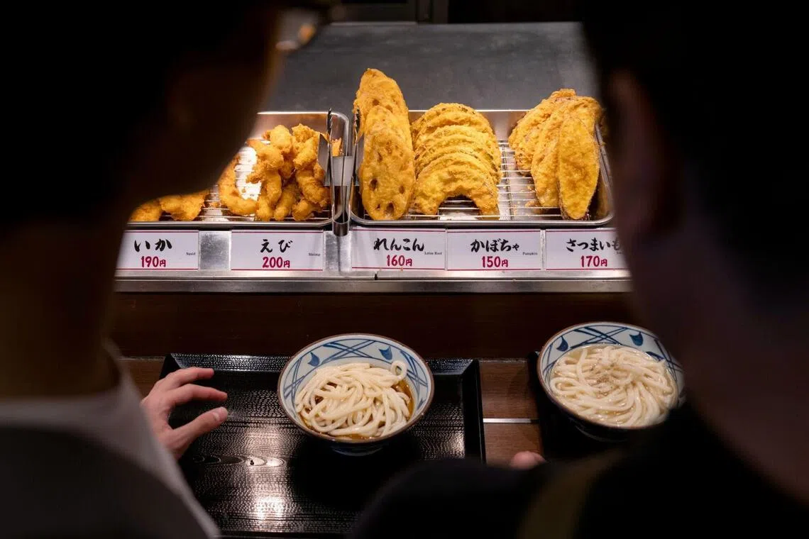 Tempura side dishes are displayed for customers at a Marugame Seimen restaurant in Tokyo, Japan, on Monday, July 27, 2026. Takaya Awata, founder and chief executive officer of Toridoll Holdings Corp., wants the company, with almost ¥280 billion ($1.8 billion) in annual revenue, to join the trillion-yen ranks of the world’s largest fast-food chains, primarily by growing its flagship Marugame Udon brand. Photographer: Louise Delmotte/Bloomberg