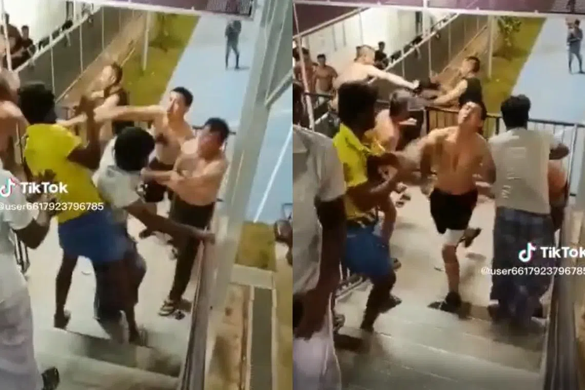 In videos shared on social media, migrant workers can be seen fighting each another in a stairwell.