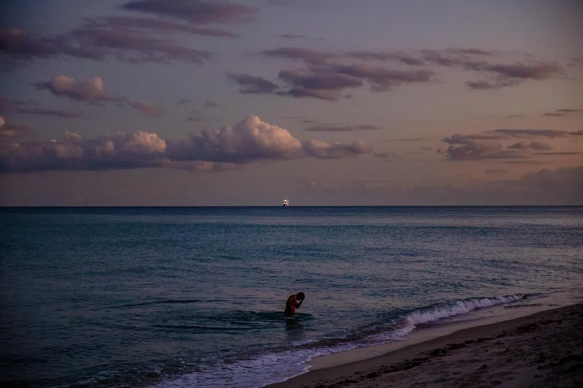FILE Ñ A swimmer in the Atlantic Ocean in Miami Beach, Fla. on Jan. 13, 2022. The system of ocean currents in the North Atlantic, which regulates the climate for a swath of the planet, could collapse sooner than expected, a new analysis found. (Scott McIntyre/The New York Times)