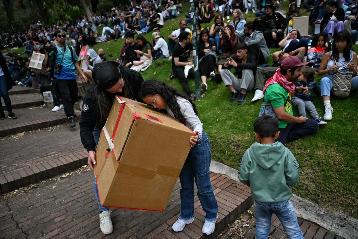 People using a box pinhole projector to watch the annular solar eclipse in Bogota, Colombia, on Oct 14, 2023. 