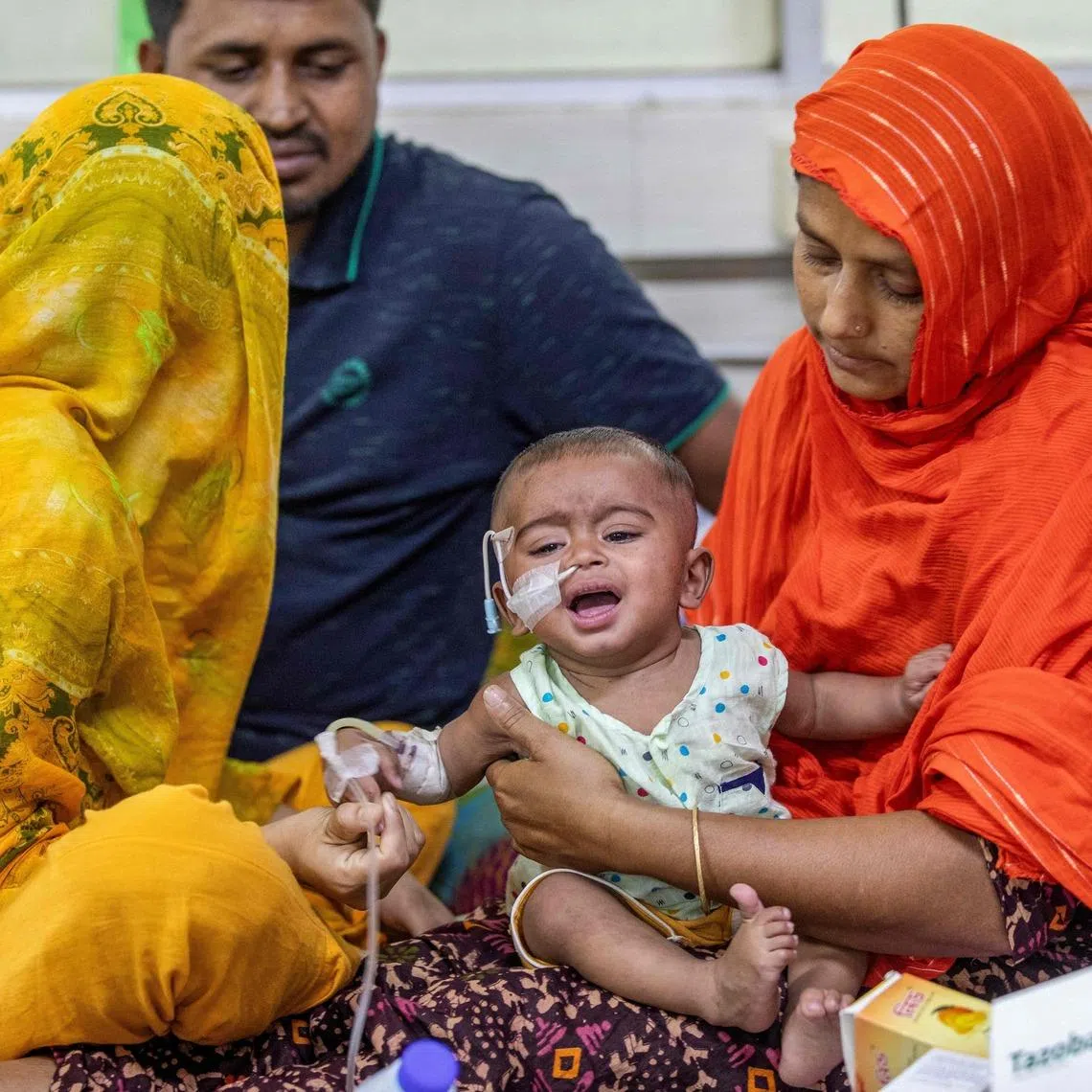 A woman comforts a child diagnosed with measles at the Bangladesh Shishu Hospital and Institute in Dhaka on May 6. Doctors are struggling to contain a surge in infections among children.