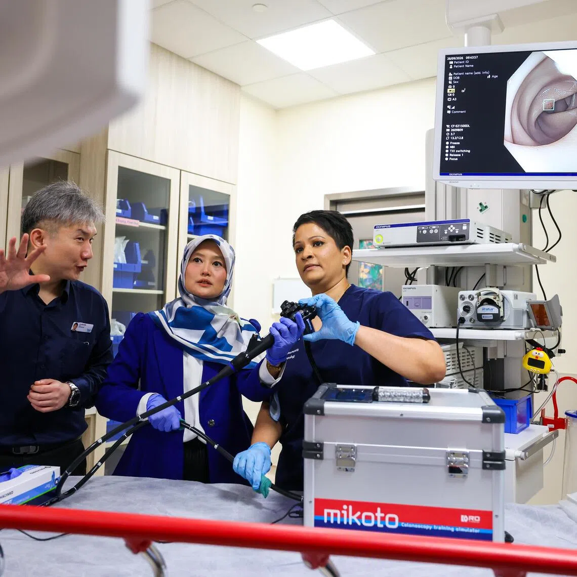 Head of the department of gastroenterology and hepatology at Woodlands Hospital Christopher Chia (left) and consultant Sasha Shoba Devi Thrumurthy (right) demonstrating what is seen through the endoscope to Minister of State for Health Rahayu Mahzam.