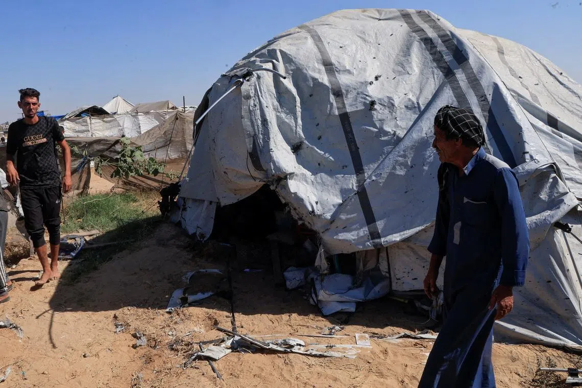 Palestinians inspect the site of an Israeli strike on a tent in Khan Younis, in the southern Gaza Strip, July 8, 2026. REUTERS/Haseeb Alwazeer