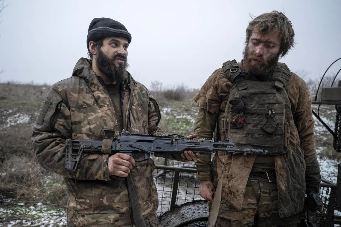 Ukrainian servicemen show off a trophy Russian weapon, after returning from front-line positions near Kostyantynivka, in Ukraine's Donetsk region.