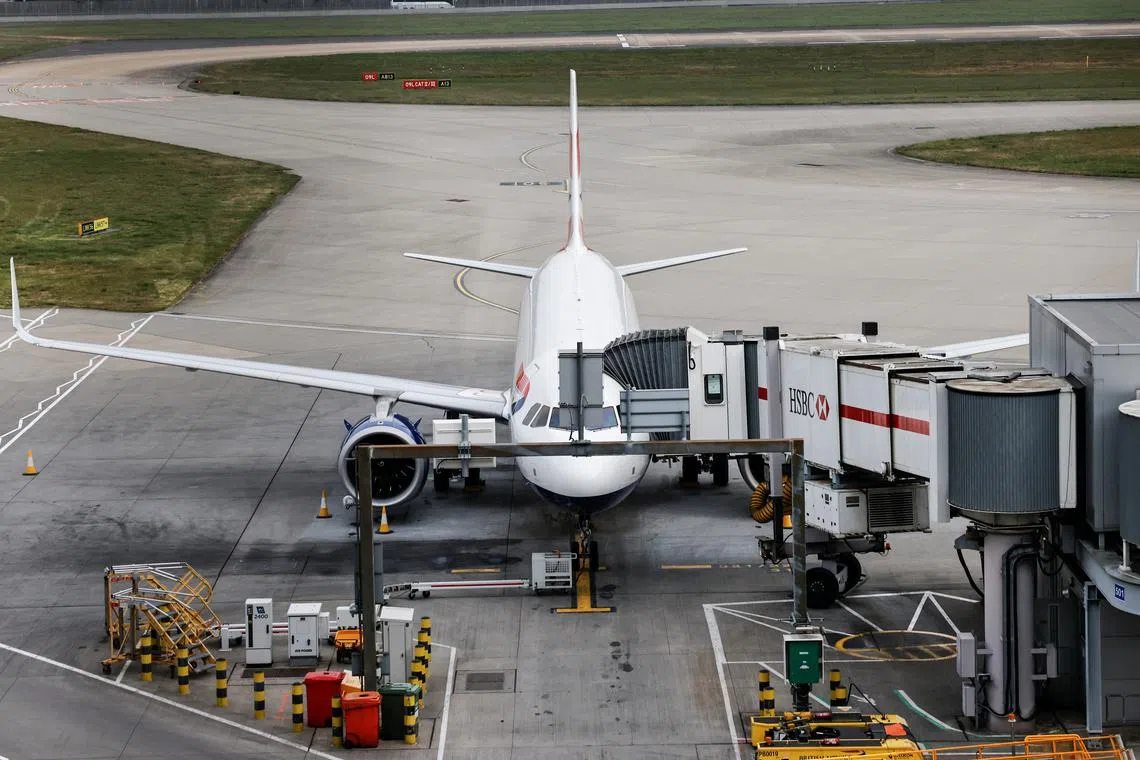 An airplane remains parked on the tarmac at Heathrow International Airport after a fire at a nearby electrical substation wiped out the power at the airport, near London, Britain, March 21, 2025. REUTERS/Carlos Jasso