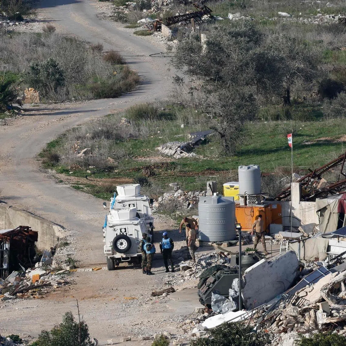 UN peacekeepers with the UN Interim Force in Lebanon standing with Lebanese soldiers next to destroyed buildings and cars in the southern Lebanese village of Dhayra on Jan 8.