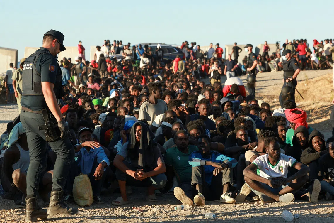Migrants waiting to receive food from the Red Cross in Ceuta, Spain, on Aug 3, following mass crossings of migrants on foot and by sea from Morocco into Spanish territory.