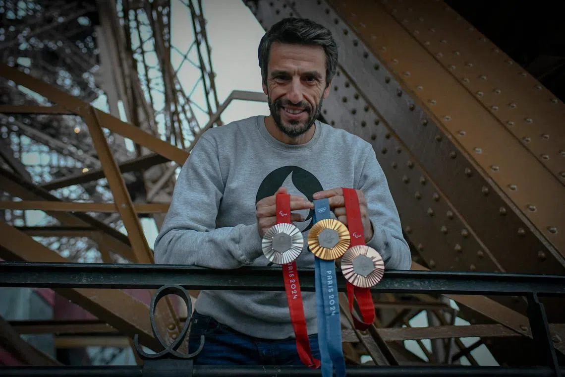 French president of the Paris 2024 organising committee Tony Estanguet poses with this summer's Games medals at the Eiffel Tower.