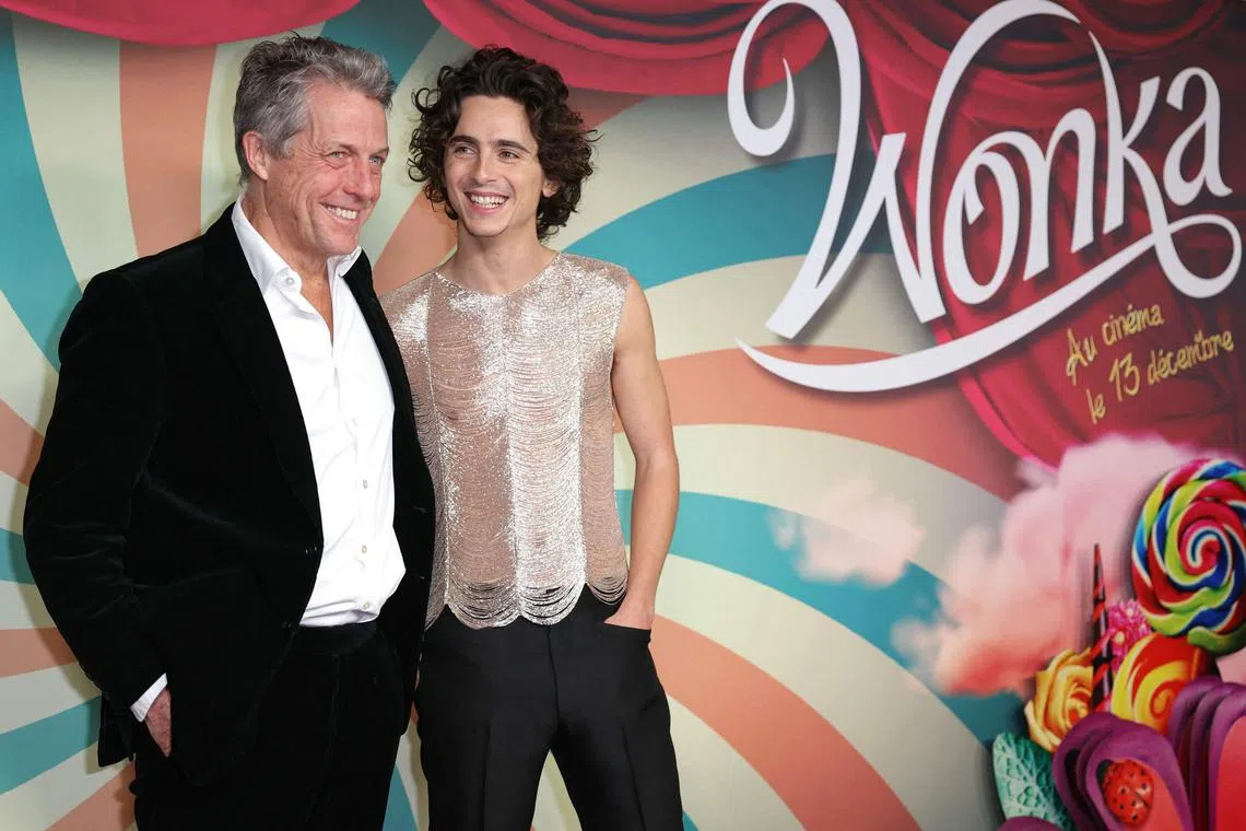 French-US actor Timothee Chalamet (R) and English actor Hugh Grant pose on the red carpet upon arrival for the Premiere of the film "Wonka" at the UGC Normandie cinema in Paris, on December 1, 2023. (Photo by Thomas SAMSON / AFP)