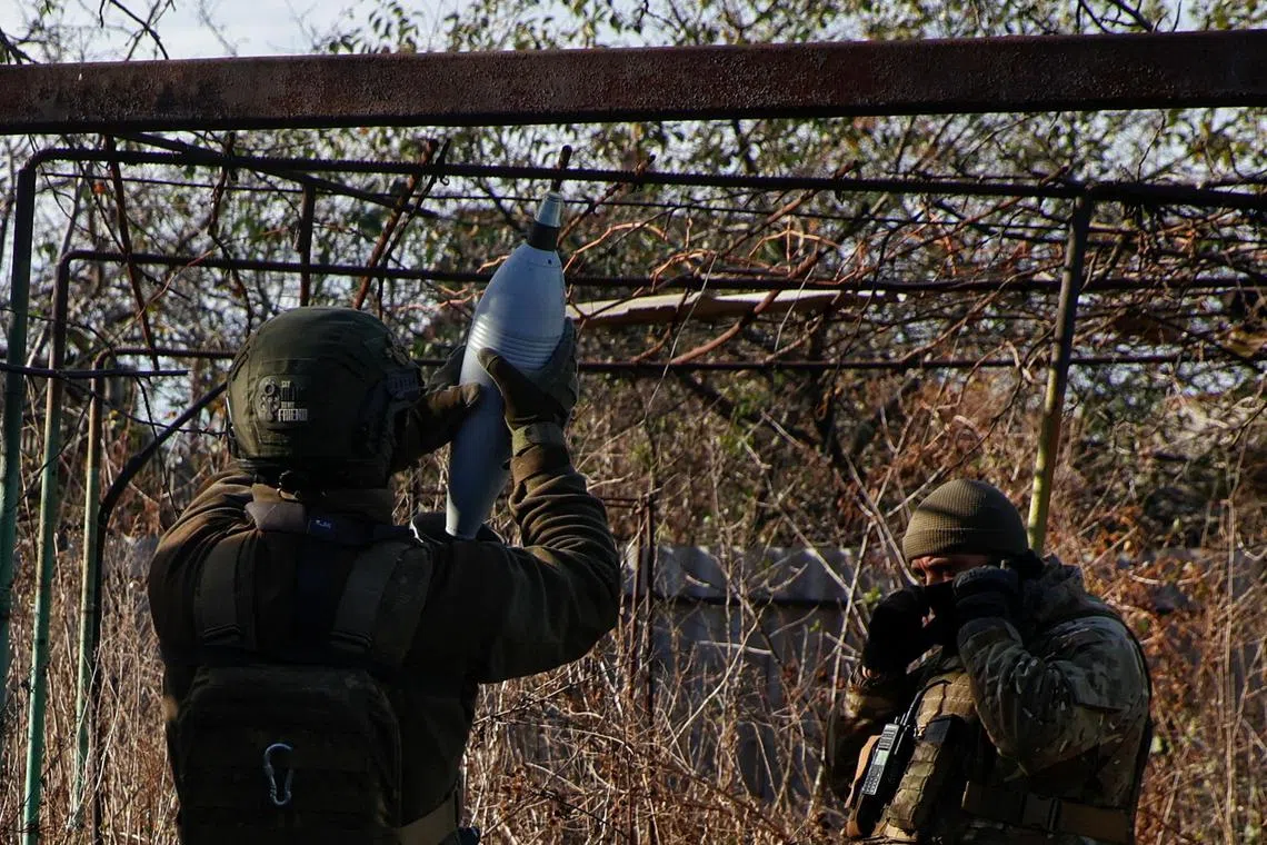 Ukrainian servicemen fire a mortar towards Russian troops, in the front line town of Avdiivka, in Ukraine's Donetsk region.