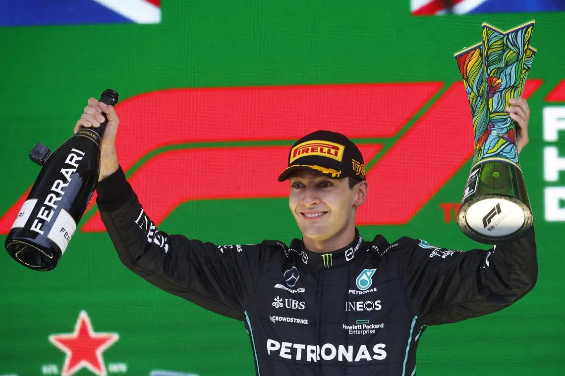 Mercedes' George Russell celebrates on the podium with the trophy after winning the Brazilian Grand Prix.