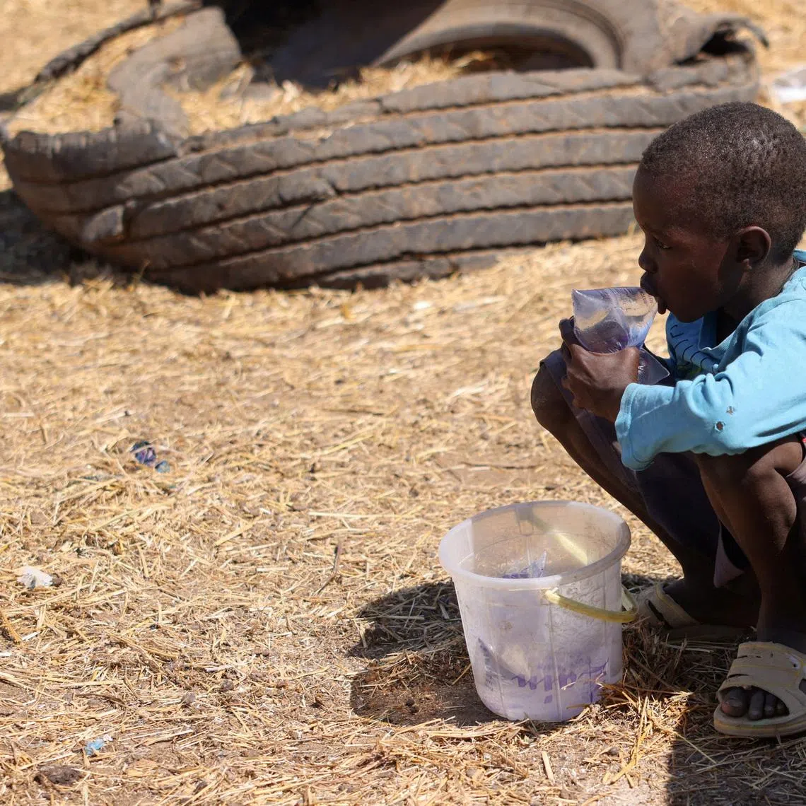 FILE PHOTO: A boy drinks water as he waits for customers to sell bags of water along a roadside on the outskirts of N’Djamena, Chad, November 15, 2025. REUTERS/Amr Abdallah Dalsh/File Photo
