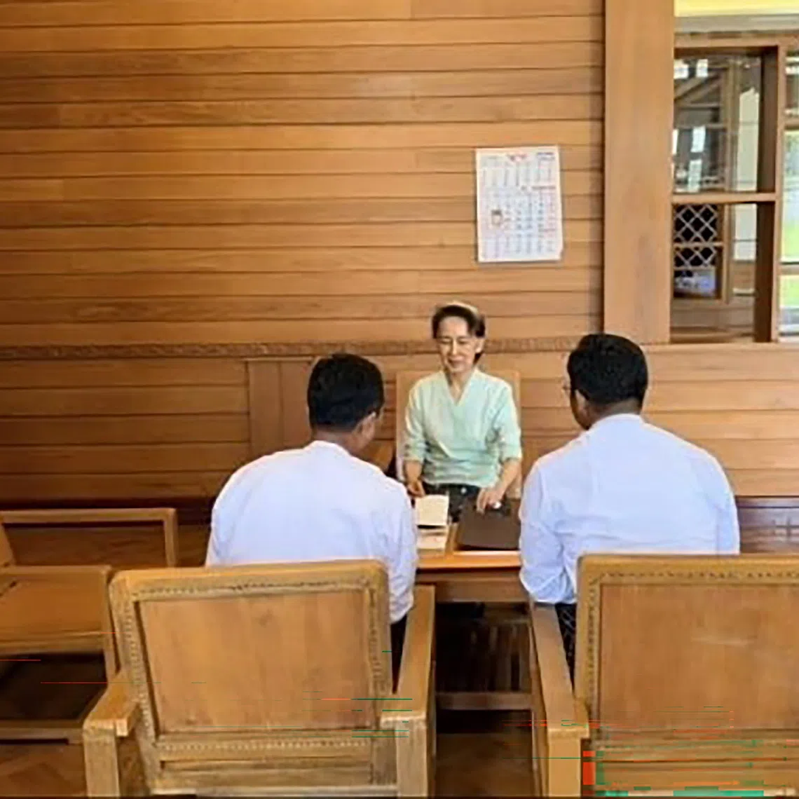 Myanmar’s former leader Aung San Suu Kyi receives books and a letter from Britain’s King Charles from a Myanmar official in Naypyitaw on Oct 19.