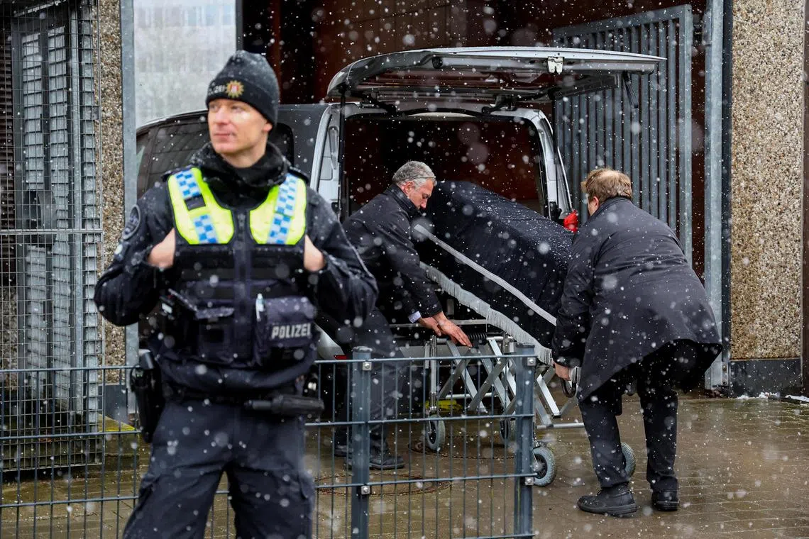 Undertakers remove the body of a victim of the deadly shooting, on March 10, 2023.   