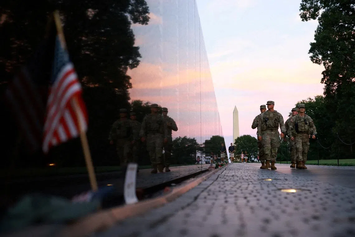 FILE PHOTO: Members of the National Guard walk through the Vietnam Veterans Memorial on the National Mall after U.S. President Donald Trump deployed the National Guard and ordered an increased presence of federal law enforcement to assist in crime prevention, in Washington, D.C., U.S., August 23, 2025. REUTERS/Jose Luis Gonzalez/File Photo