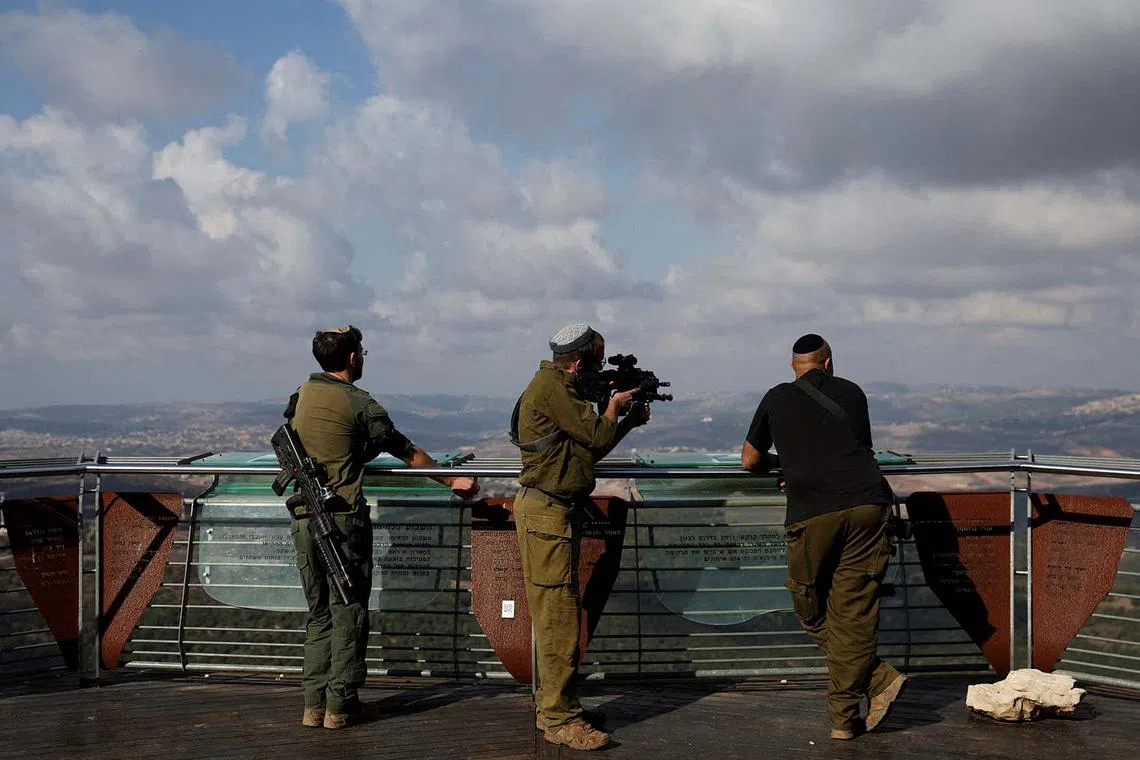 An Israeli soldier looks through the scope of a rifle into southern Lebanon from Israel, amid ongoing hostilities between Hezbollah and Israeli forces, northern Israel, November 4, 2024. REUTERS/Violeta Santos Moura TPX IMAGES OF THE DAY