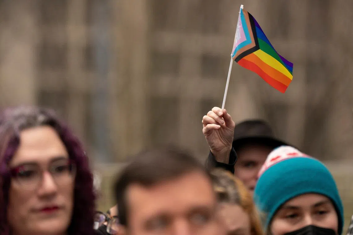 FILE PHOTO: A supporter holds a Pride flag in Seattle, Washington, U.S., February 14, 2025.  REUTERS/David Ryder/File Photo