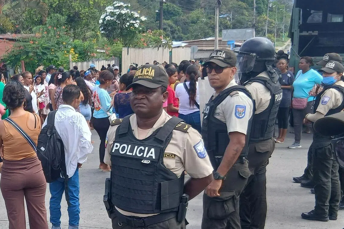 Police officers standing guard at a prison in Esmeraldas, Ecuador, on Sept 25, after clashes left at least 17 people dead.