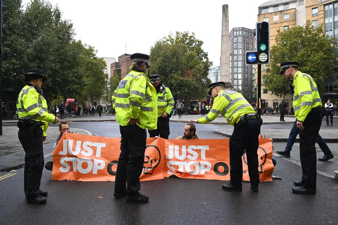 epa10240287 'Just Stop Oil' protesters block roads during a demonstration in central London, Britain, 13 October 2022. 'Just Stop Oil' is a coalition of groups working to ensure the Government commits to halting new fossil fuel licensing and production. 'Just Stop Oil' has stated that it will continue to 'occupy' Westminster until the government stops news licensing for fossil fuel production. EPA-EFE/ANDY RAIN