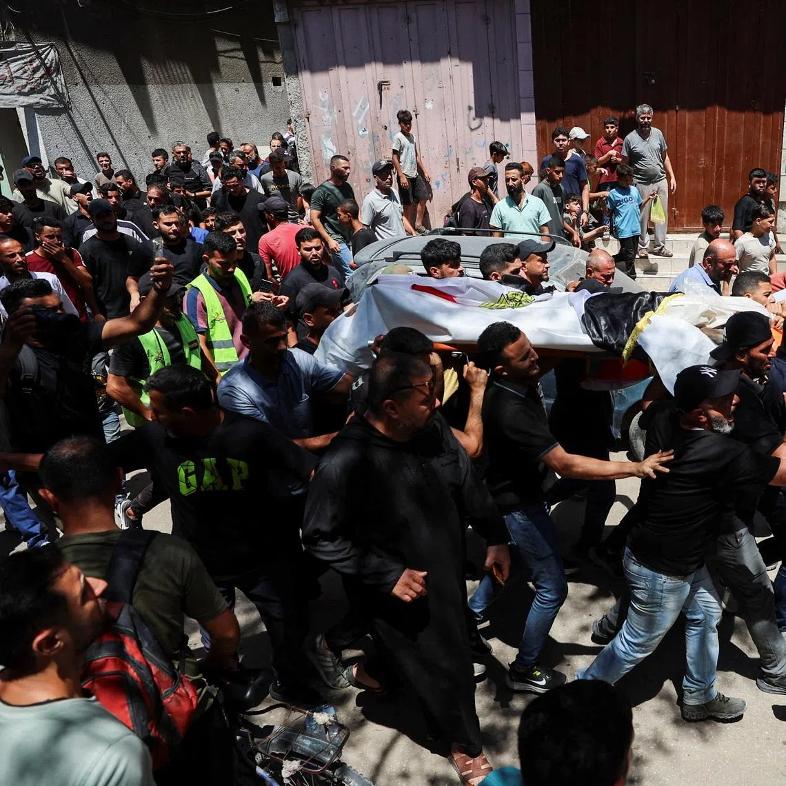 Mourners carry the body of Palestinian man Mohammad al-Waheidi, who worked for the Egyptian Relief Committee and was killed in an Israeli strike on Tuesday, during his funeral, in Gaza City, July 8, 2026. REUTERS/Dawoud Abu Alkas