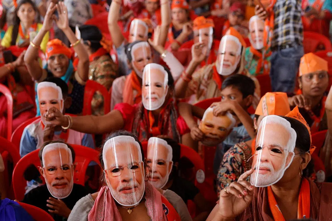 Supporters of India's Prime Minister Narendra Modi wear masks of his face, as they attend an election campaign rally in Meerut, India.