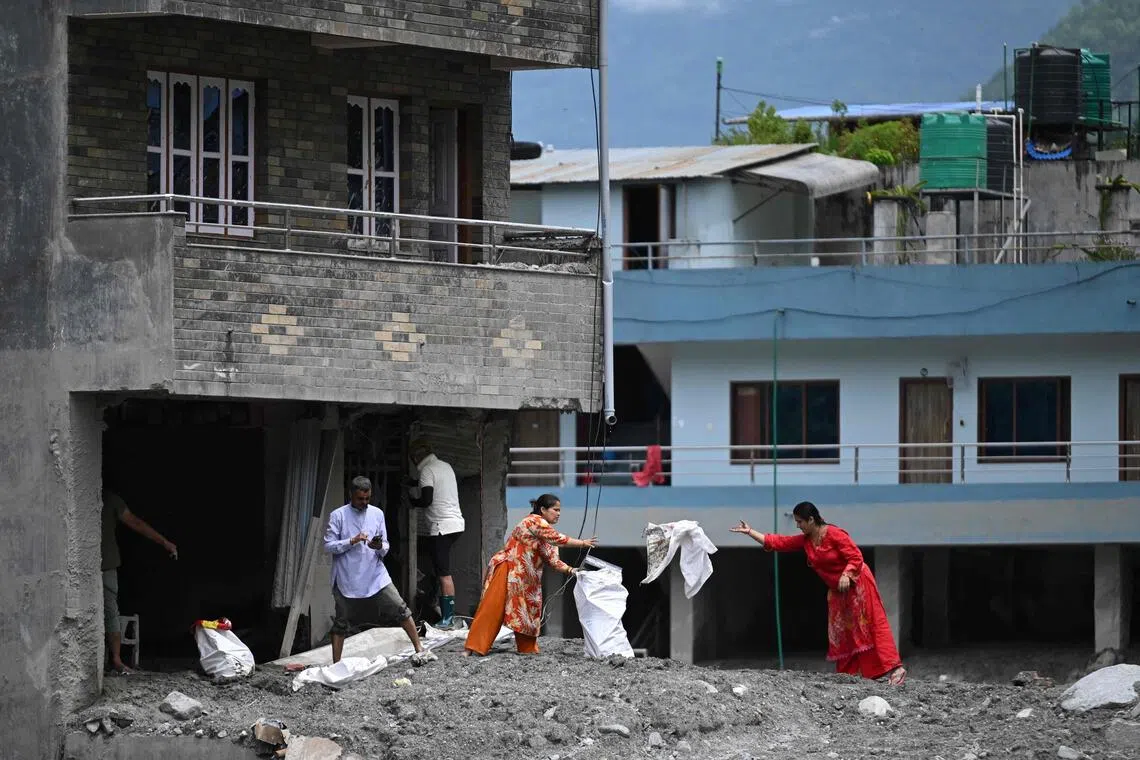 Residents salvage belongings in the aftermath of flash floods at Trishuli Centre in Nepal’s Nuwakot district on Aug 30.