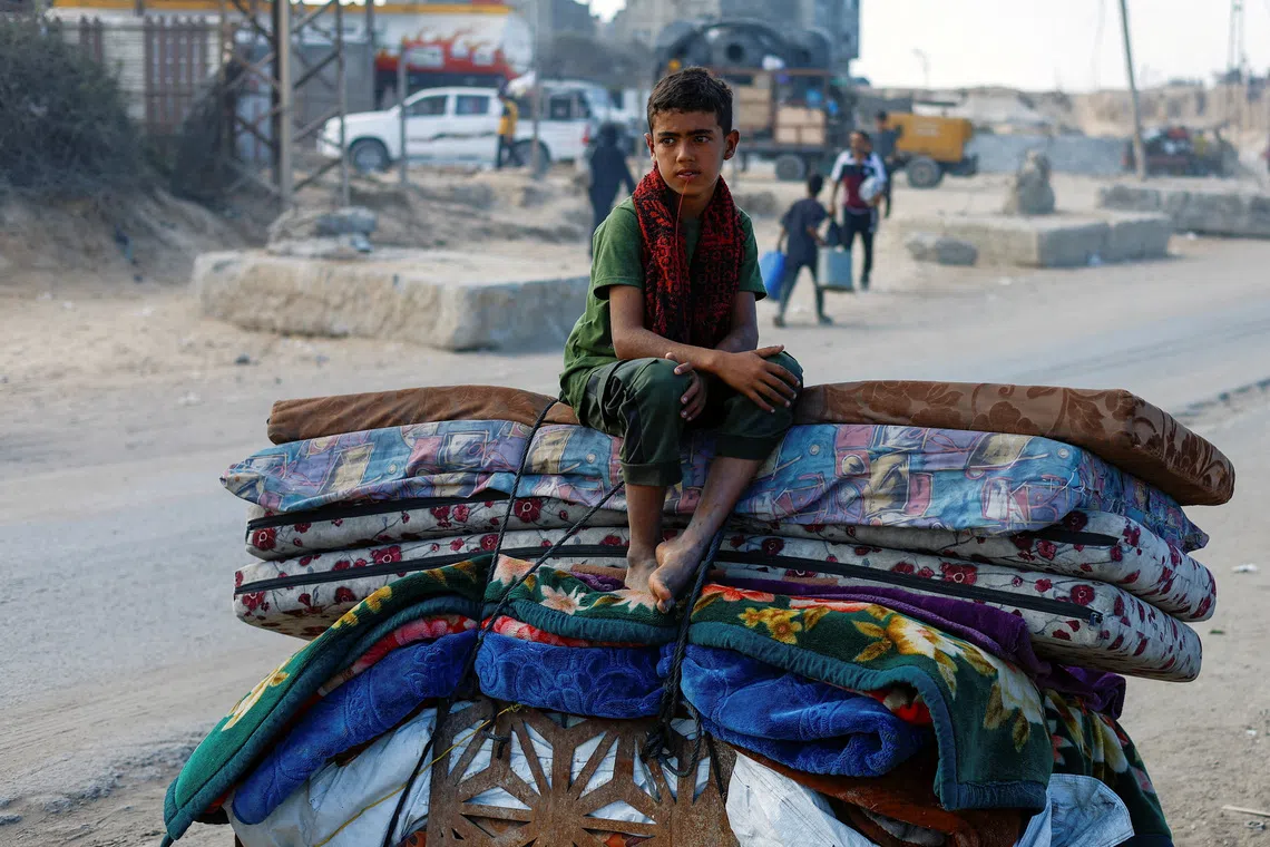 A displaced Palestinian boy, fleeing northern Gaza due to an Israeli military operation, sits atop belongings as he moves southward after Israeli forces ordered residents of Gaza City to evacuate to the south, in the central Gaza Strip September 17, 2025. REUTERS/Mahmoud Issa