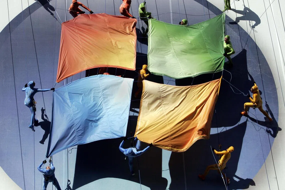 (FILES) A group of performers from the Grounded Aerial Dance Theater unfurl the Microsoft logo against a building as part of the Microsoft Windows Vista operating system launch, 29 January 2007, in New York. Microsoft has been at the heart of computing for half a century, becoming a tech stalwart almost taken for granted as lifestyles embraced the internet. As the Redmond, Washington-based company founded with a vision of putting computers in every home and office celebrates its 50th anniversary on April 4, it looks to boost its fortunes by being a leader in artificial intelligence. (Photo by STAN HONDA / AFP)