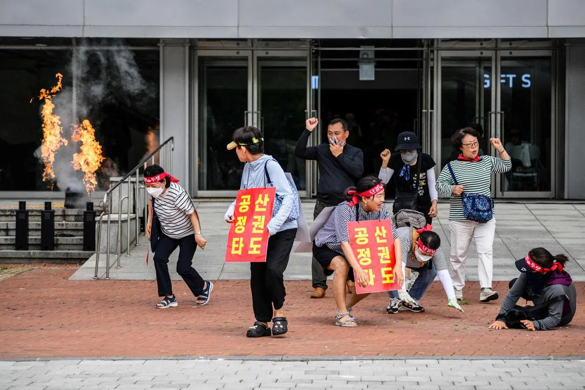 Mock protesters wearing placards that read ‘Destroy the communist regime’ take part in an anti-terror drill in Seoul. The incident serves as a reminder that in South Korea, jokes involving communism do not translate well.