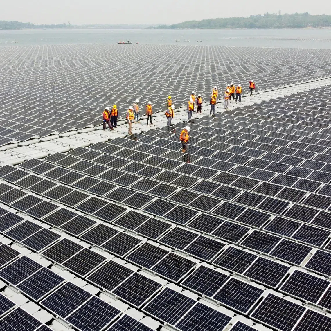 FILE PHOTO: Workers walk between solar cell panels over the water surface of Sirindhorn Dam in Ubon Ratchathani, Thailand April 8, 2021. Picture taken April 8, 2021 with a drone. REUTERS/Prapan Chankaew/File Photo