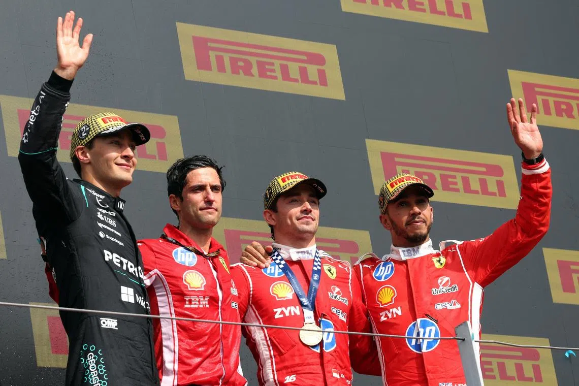 Formula One F1 - British Grand Prix - Silverstone Circuit, Silverstone, Britain - July 5, 2026 Ferrari's Charles Leclerc celebrates on the podium after winning the British Grand Prix with Mercedes' George Russell who finished second and Ferrari's Lewis Hamilton who finished third REUTERS/Suzanne Plunkett