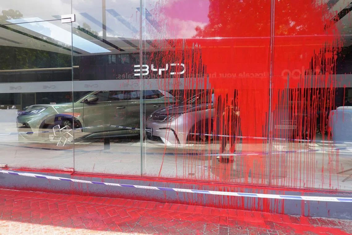A general view of a splattered BYD store while police cordons are visible at the scene in Hong Kong.
