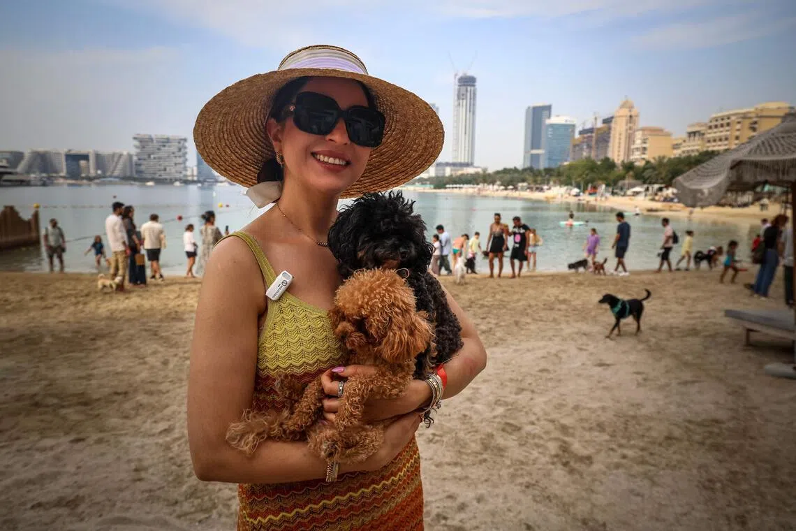 A woman poses for a picture with her dog during the Barkfest dog festival at Barasti Beach in Dubai on April 4. 