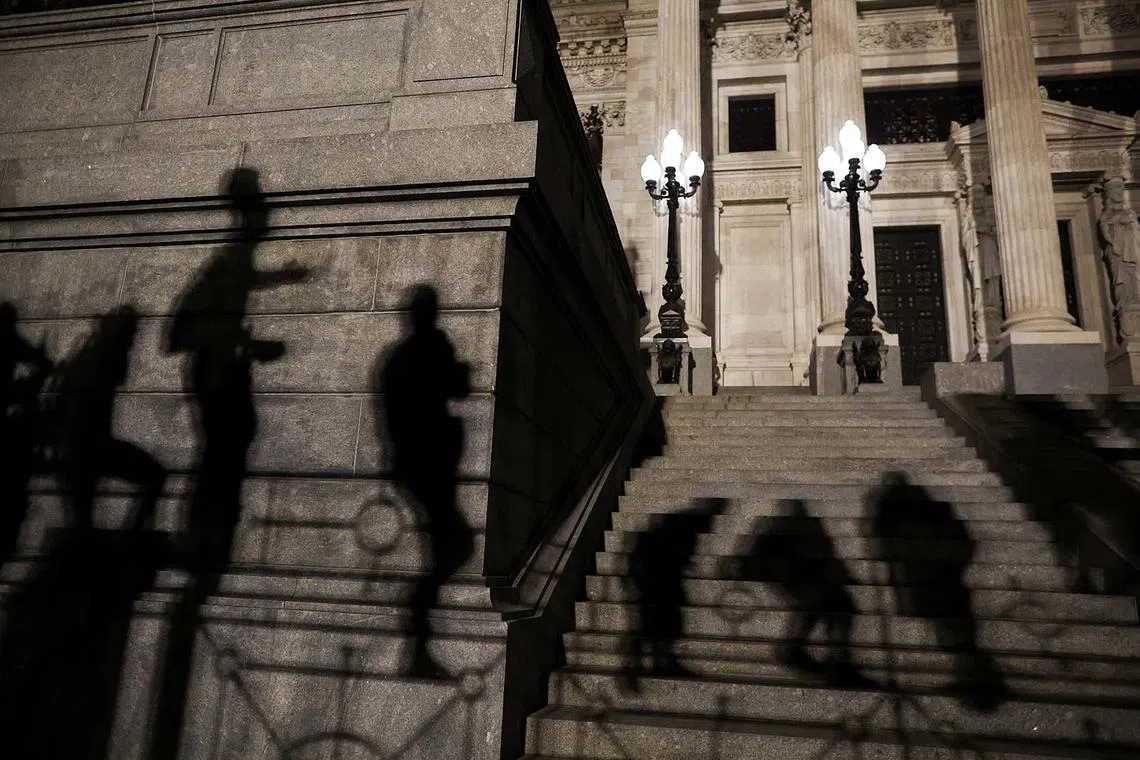 Demonstrators cast their shadows on the building of the National Congress during a protest against Argentina's new President Javier Milei's adjustment policy, in Buenos Aires, Argentina, Dec 21, 2023. 
