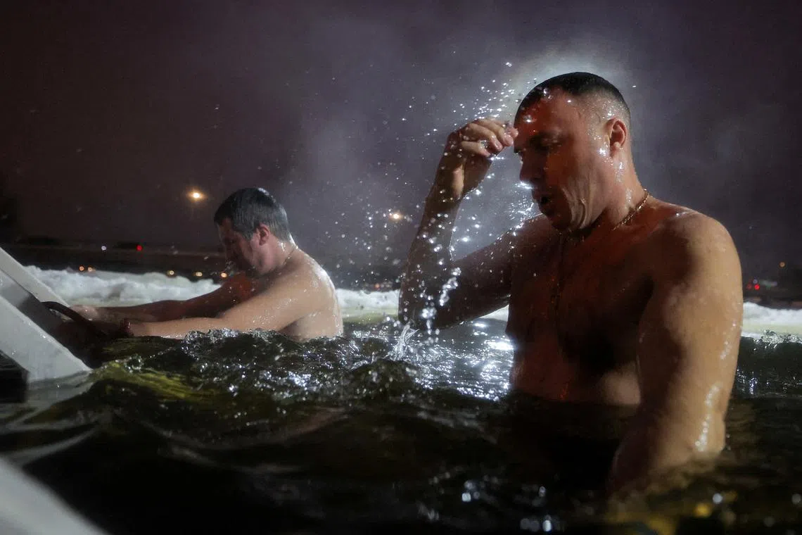Men immersing themselves into icy waters of the Izhora River during celebrations of the Orthodox Christian feast of Epiphany, in the town of Kolpino outside Saint Petersburg, Russia, on Jan 18, 2026. 