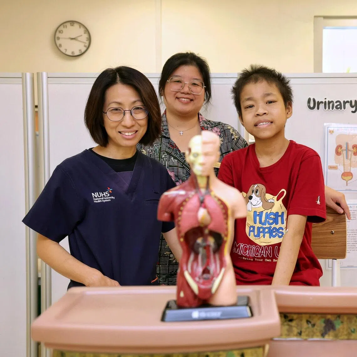 Au Wan Rong (right), 16, has a rare mutation in the TRPC6 gene that caused his kidneys to fail. With him are (left) Associate Professor Ng Kar Hui and medical social worker Cheng Peizhi.