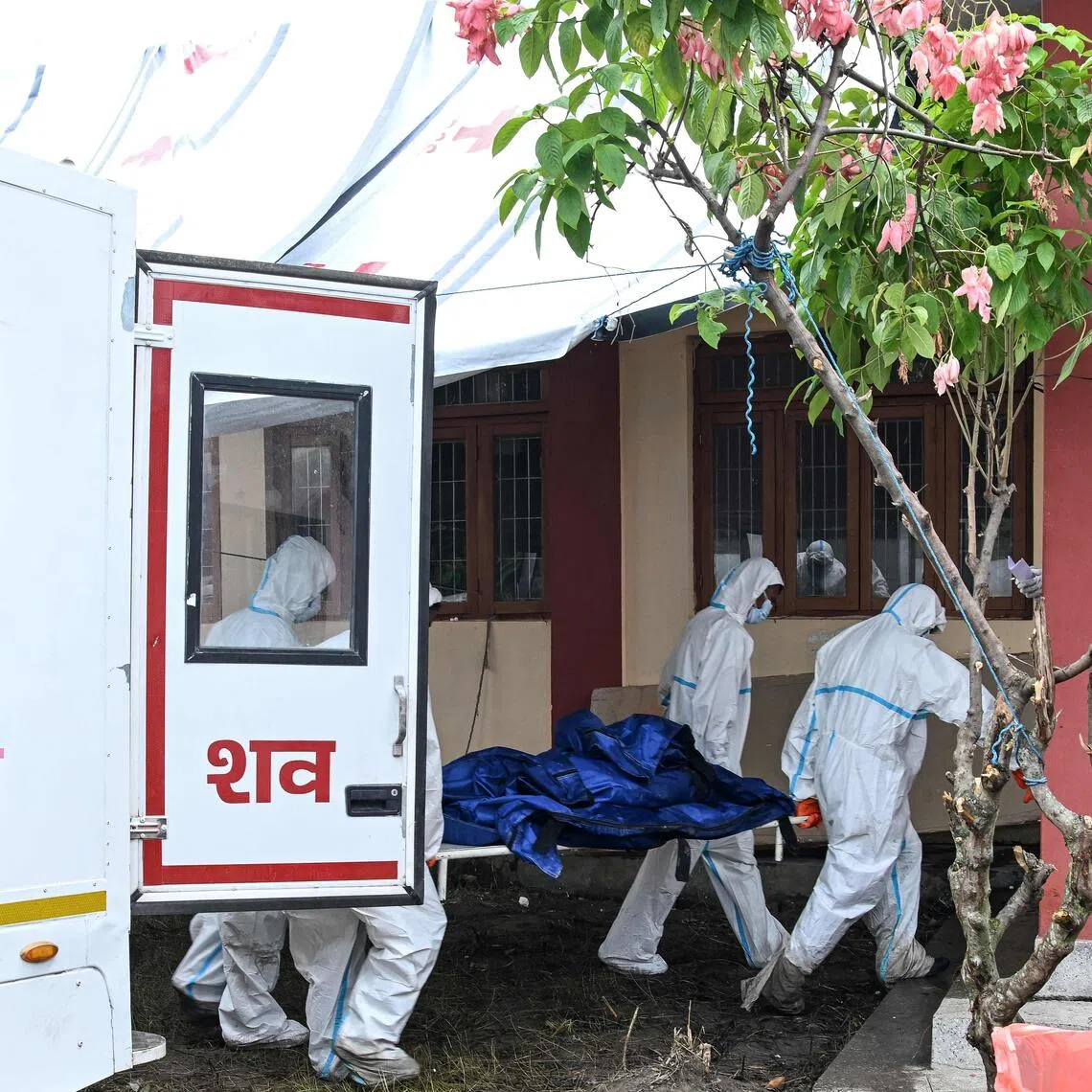 Health workers carrying a dead body at a mortuary in Nepal’s Chitwan district on Aug 30.