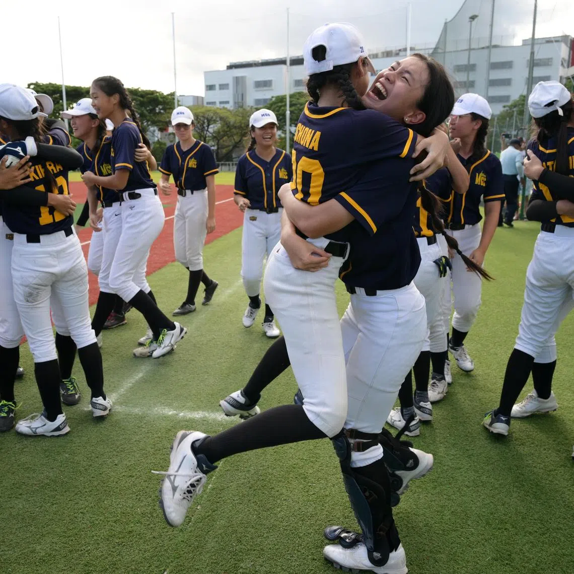 Methodist Girls' School softball team vice-captain Maeko Sng (right) celebrates captain Shona Abay Gunalan after the school retained their B Division title on March 11, 2025.