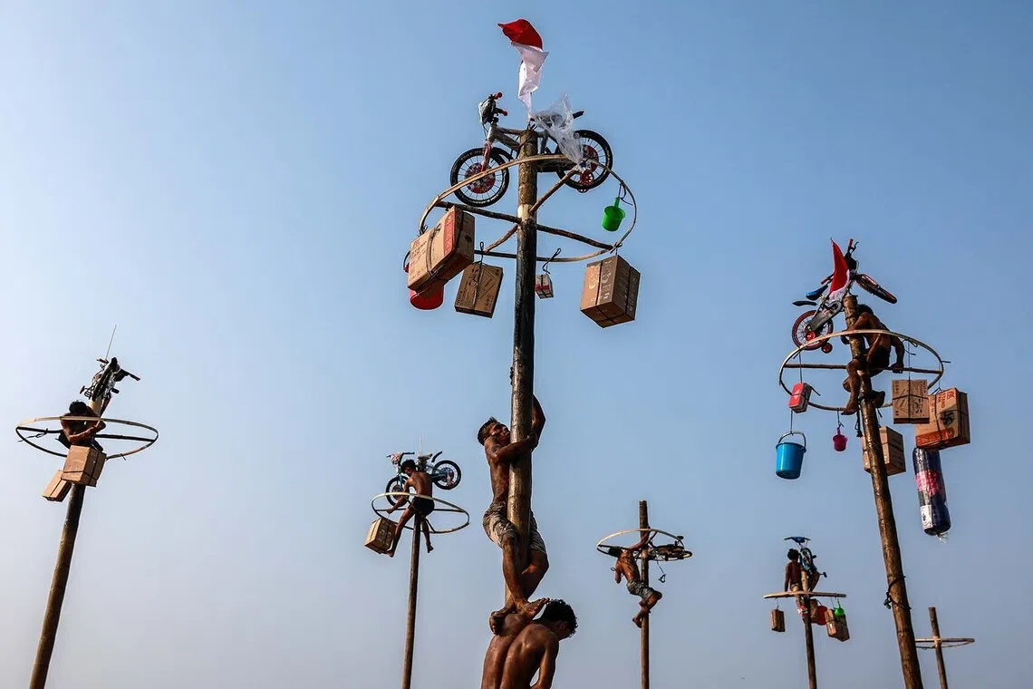 epa13175540 Participants climb during a greased pole race locally known as ’Panjat Pinang’ to mark the 81st anniversary of Indonesia's Independence Day at Ancol Beach in Jakarta, Indonesia, 17 August 2026. Indonesia gained independence from the Netherlands on 17 August 1945. EPA/MAST IRHAM