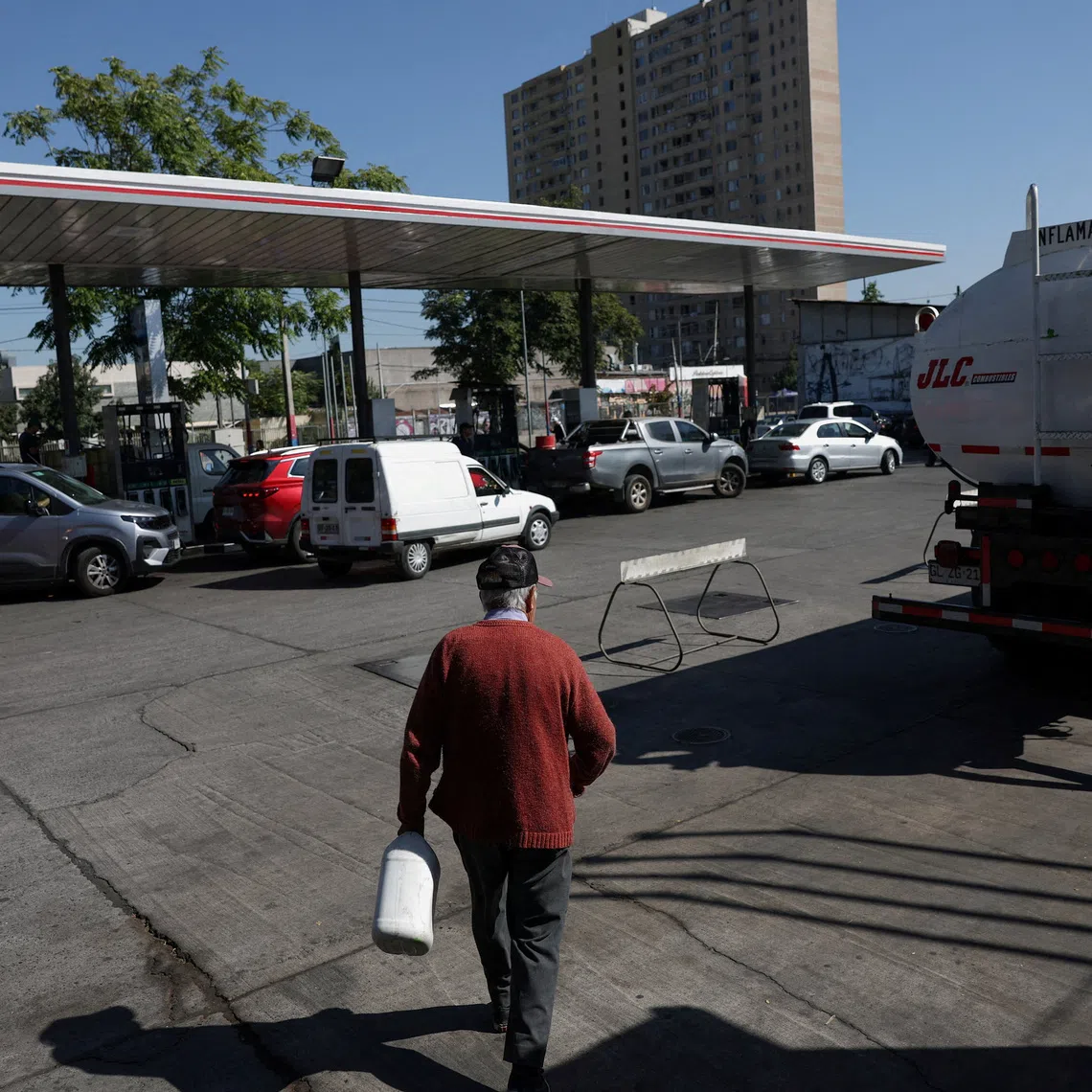 FILE PHOTO: A man walks with a canister of paraffin at a gas station as fuel prices in the country are expected to rise in Santiago, Chile, March 24, 2026. REUTERS/Pablo Sanhueza/File Photo