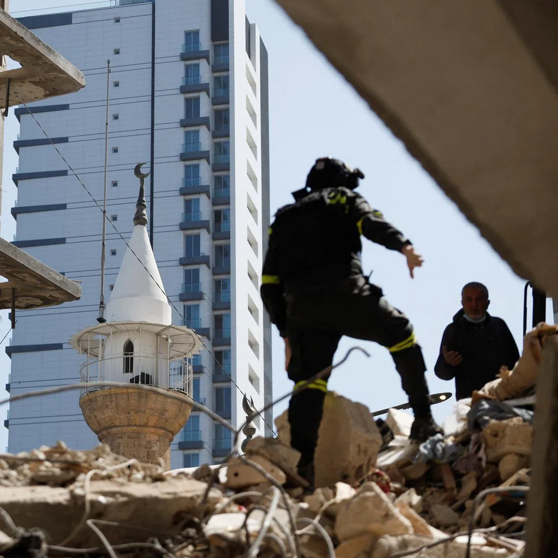 A man stands on the rubble as emergency services operate at the site of an Israeli strike carried out on Wednesday, in Ain Al Mraiseh in Beirut, Lebanon, April 9, 2026.