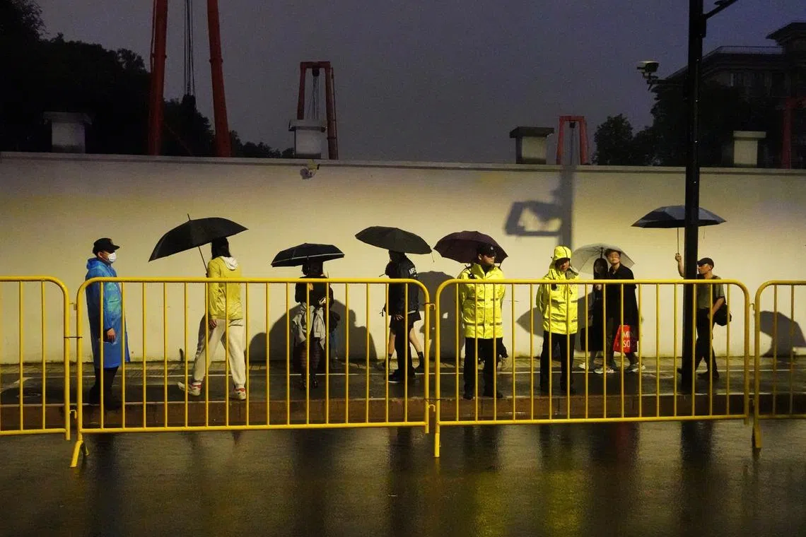 Police officers keep watch near barricades set up along Julu Road where people in Halloween costumes gathered the year before, in Shanghai, China October 26, 2024. REUTERS/Nicoco Chan