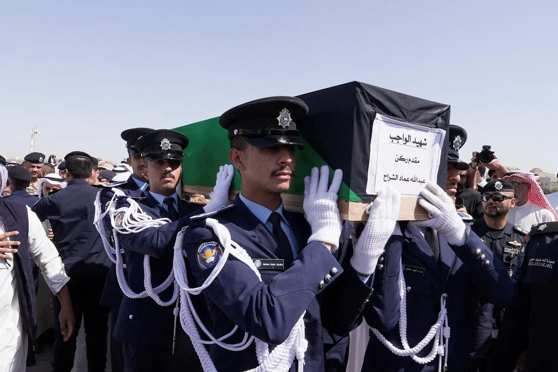 Guards of Honour carry the coffin of one of two police officers, who were killed while performing their duties, during their funeral procession at a graveyard in Kuwait City, Kuwait, March 9, 2026. REUTERS/Mohammed Benmansour