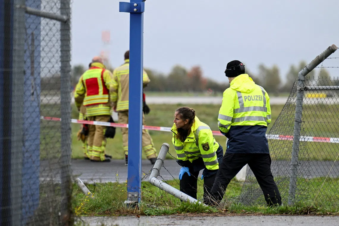 Police officers investigate a fence breach at Leipzig/Halle Airport, where a vehicle appeared to have driven through a fence, in Schkeuditz, Germany, October 18, 2026. REUTERS/Annegret Hilse