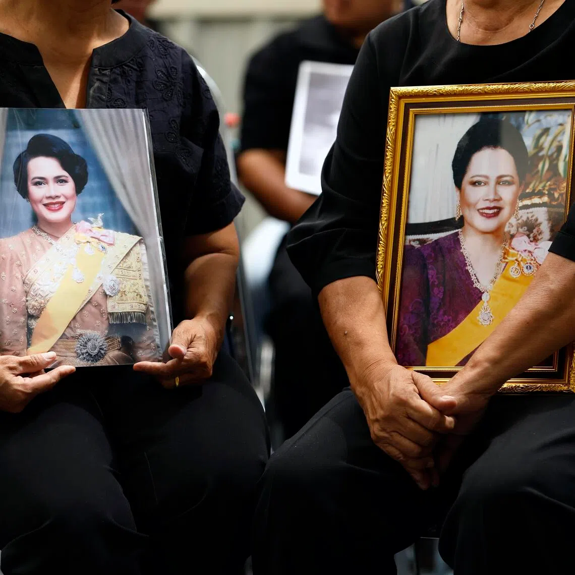 Thai women mourn with photographs of Thailand's Queen Mother Sirikit after the announcement of her death at King Chulalongkorn Memorial Hospital in Bangkok on Oct 25.